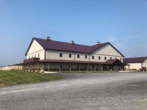 West Oaks Farm Market Main Building with gravel driveway and blue sky