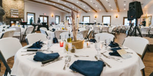 Tables with white linens and blue napkins at West Oaks Farm Market's Event Center