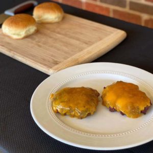 Cheeseburgers resting on a plate