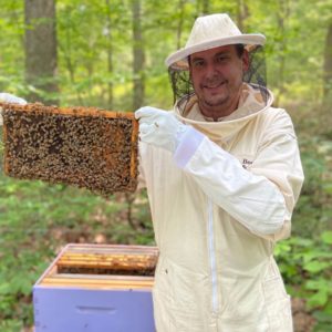 Chef Jeremy Thrasher in a bee keepers suit
