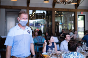 Co-Owner of Bavarian Inn Christian Asam helping guests in a mask