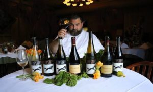 Chef Erik behind a table of wine